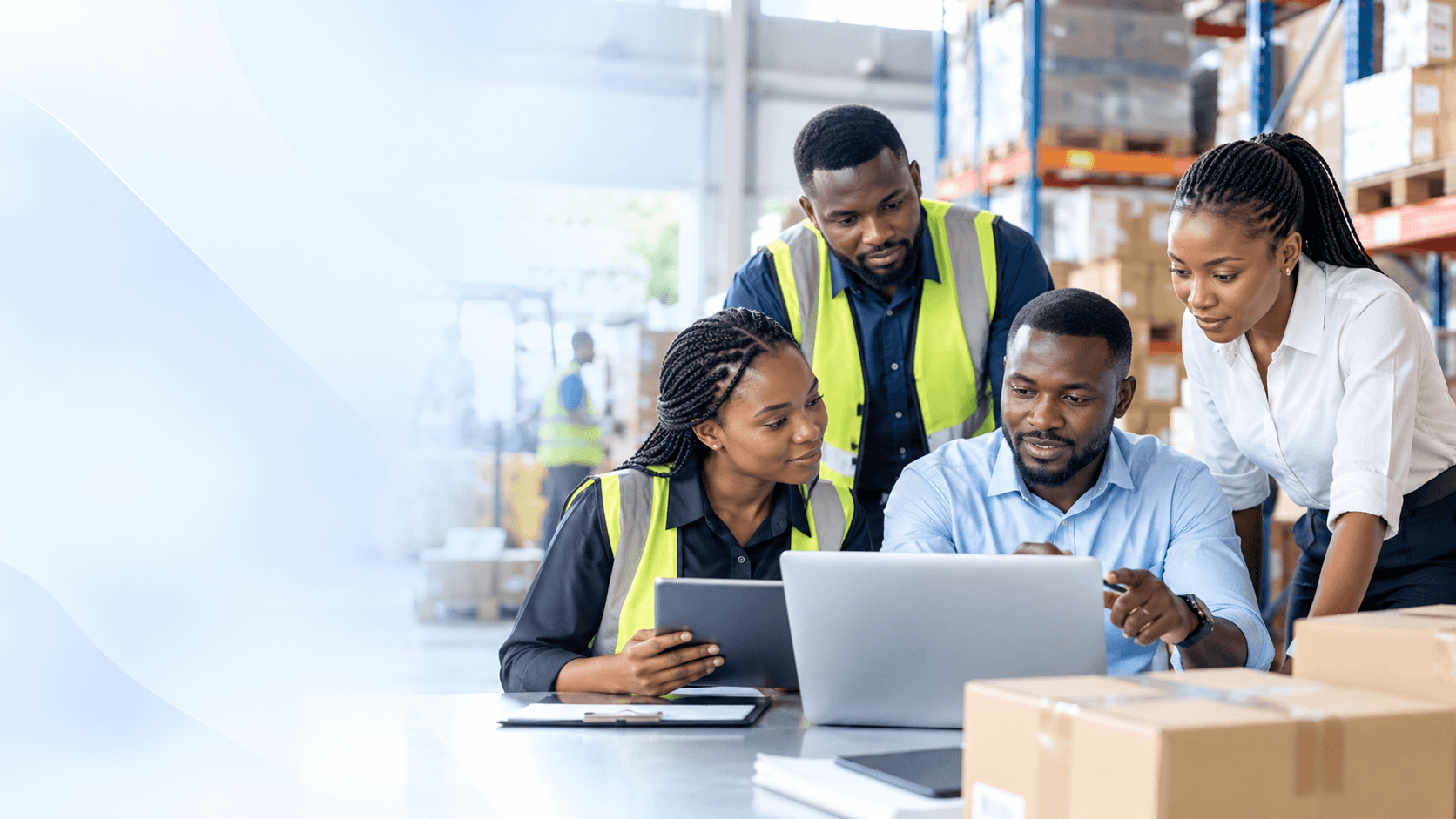 African warehouse and business operations professionals collaborating around a laptop to coordinate connected business activities.